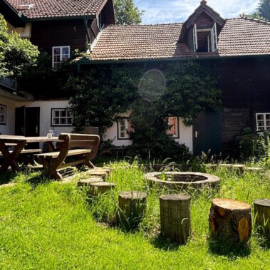 Der grüne Innenhof lädt zum Sitzen um die Feuerstelle ein. Hier kann der Abend gemütlich ausklingen.
