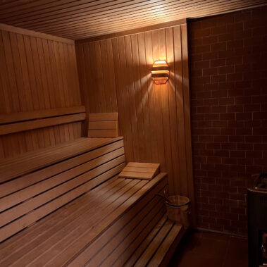 Eine große Sauna mit Ziegelwand und Holztäfelung bietet mehreren Personen Platz zur Erholung und Entspannung.