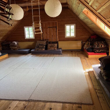 Dieser Seminarraum befindet sich im Dachraum, ist sonnenhell und geräumig mit Dachschrägen und kleinen Fenstern, die typisch sind für einen Bauernhof.